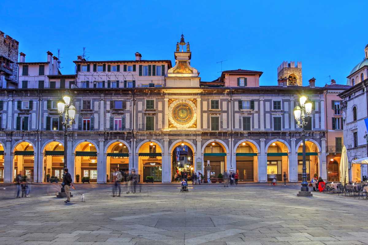 Vista notturna di Brescia con il Castello illuminato e le stelle sopra