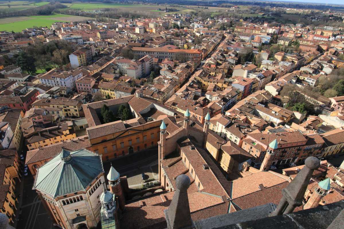 Cremona con il Torrazzo e strumenti musicali, rappresentativa della tradizione artigianale.