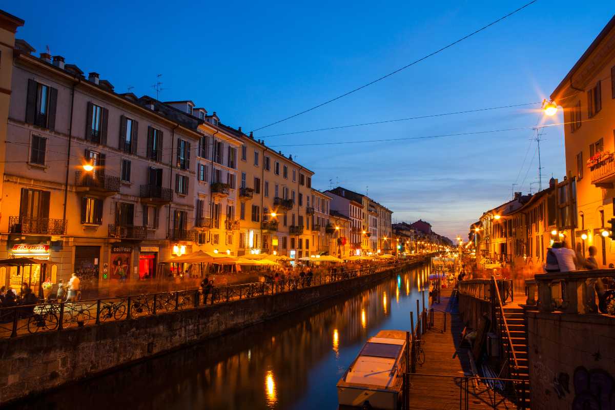 Scorcio dei Navigli di Milano al tramonto con ristoranti e bar